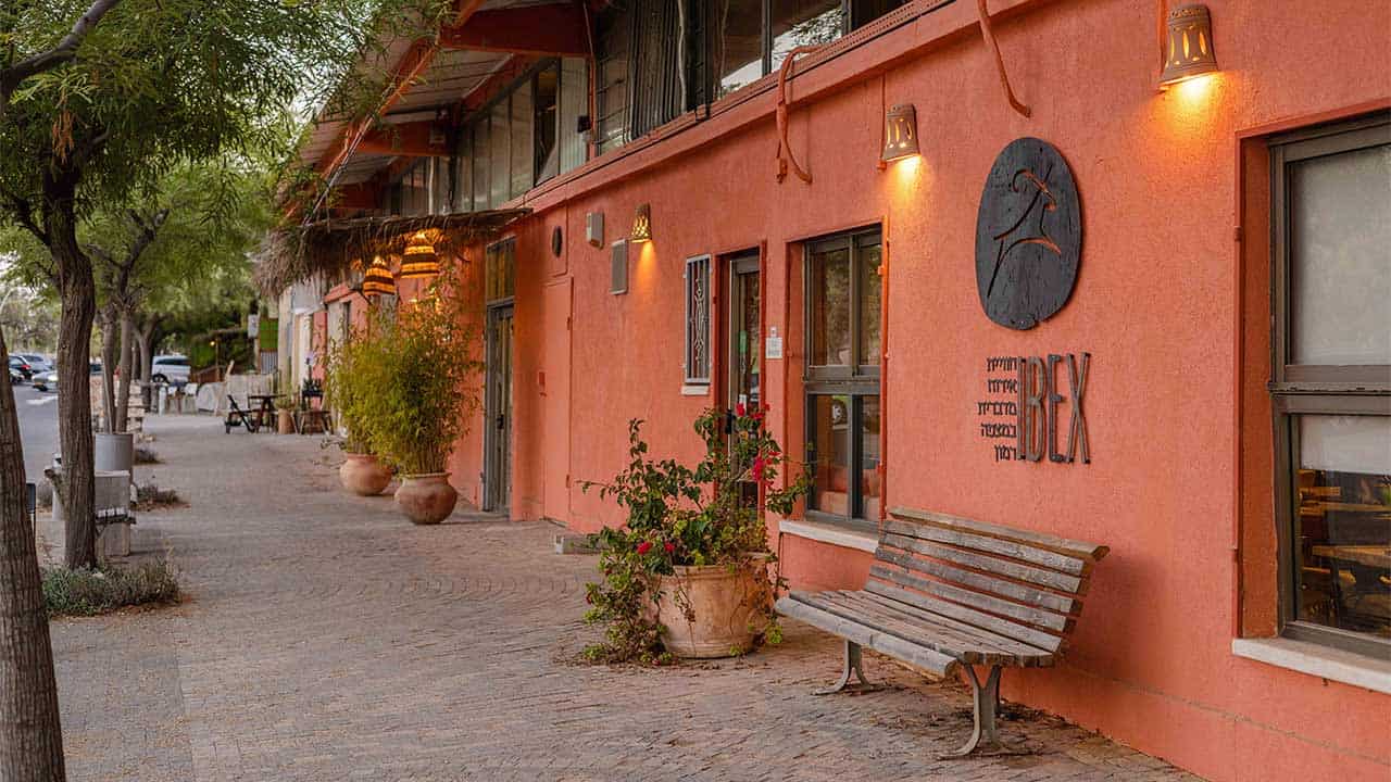 Eingang zum Perfume Road Square Hotel – rote Wand und viele Pflanzen
